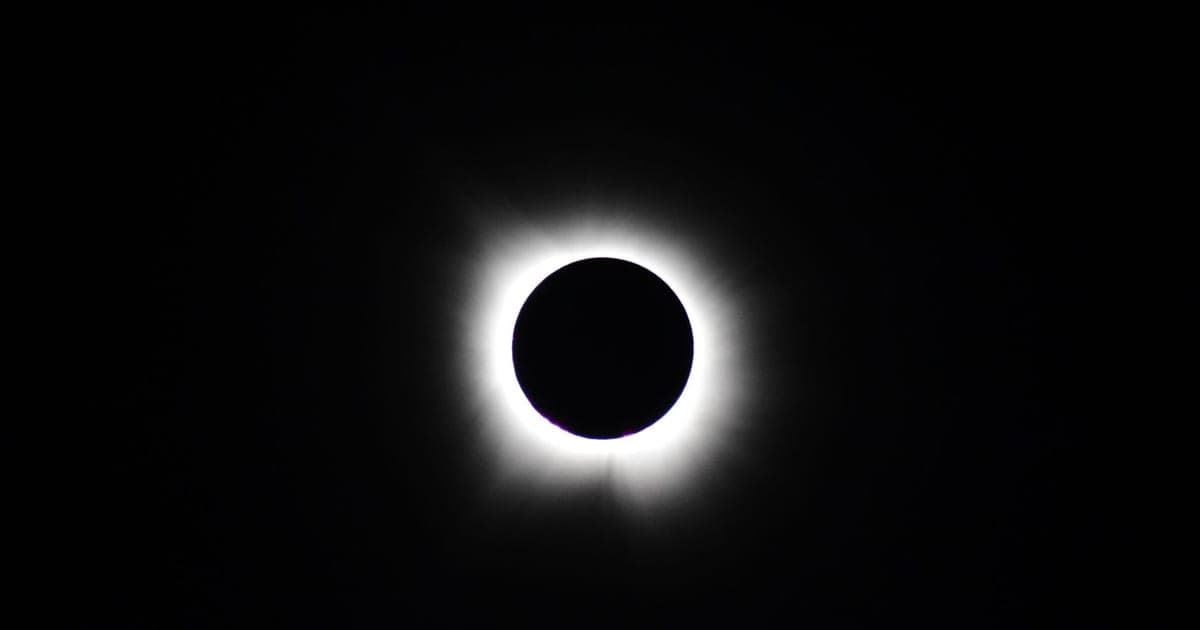 La corona bianca del Sole risplende intorno al disco scuro della Luna durante un'eclissi totale di Sole