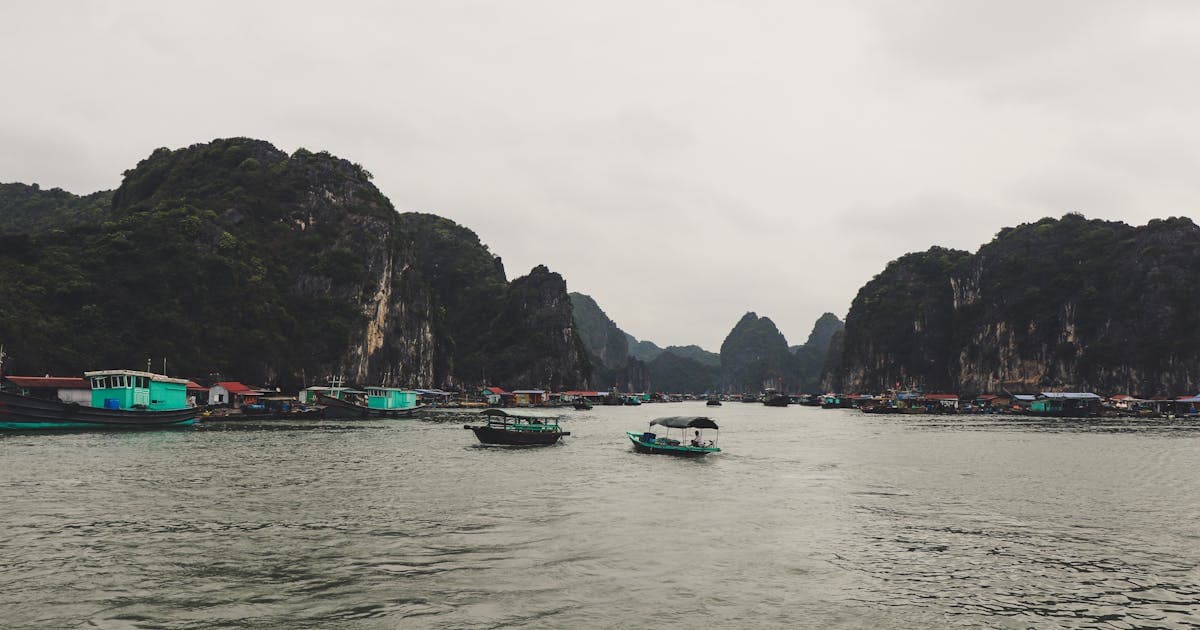 Ha Long Bay limestone karsts at sunrise with traditional junk boat, Vietnam