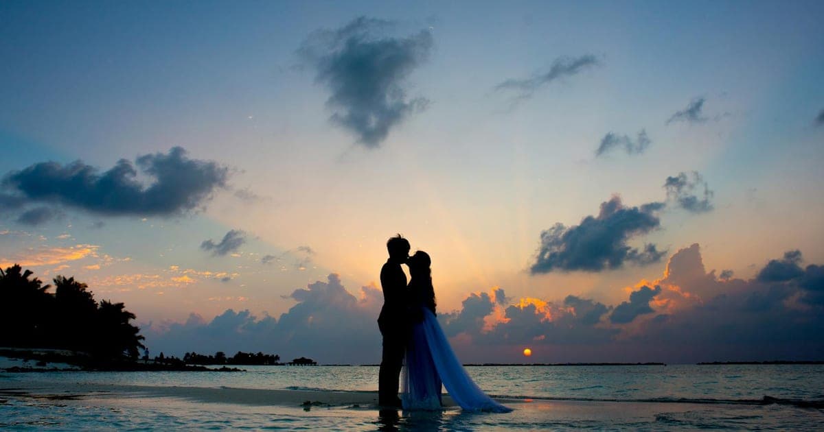 Una coppia guarda il tramonto da una terrazza privata affacciata sul mar Egeo