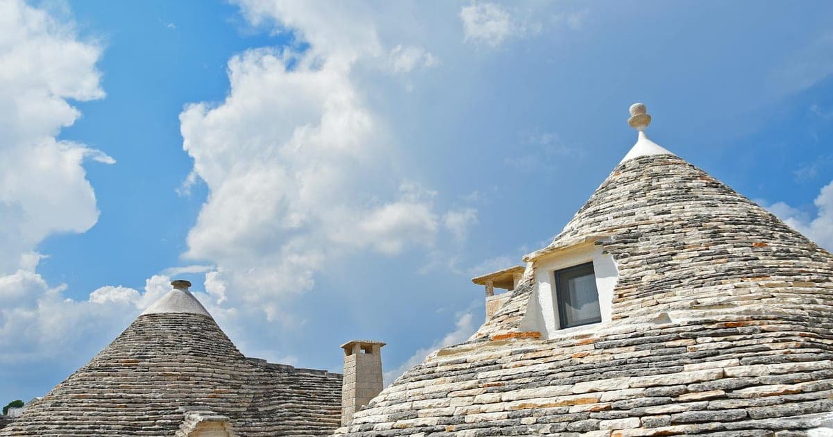Trulli houses in Alberobello with conical stone roofs and blue sky
