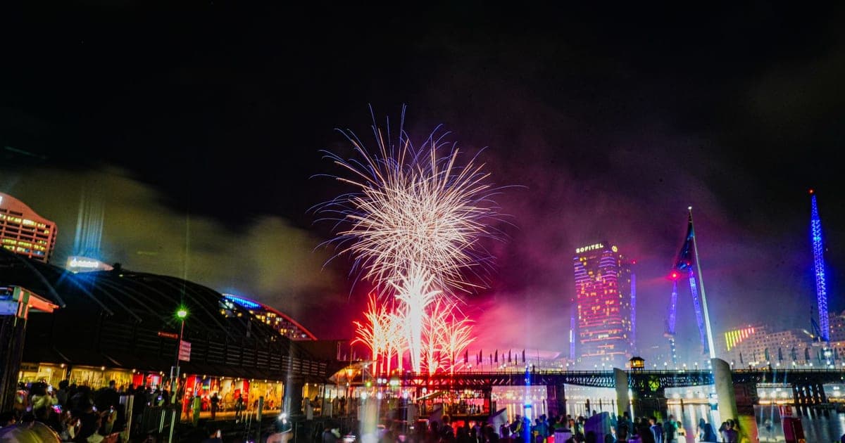 Fireworks over Darling Harbour in Sydney, with crowds watching from the waterfront